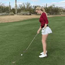 Une femme commence une partie de golf. 
